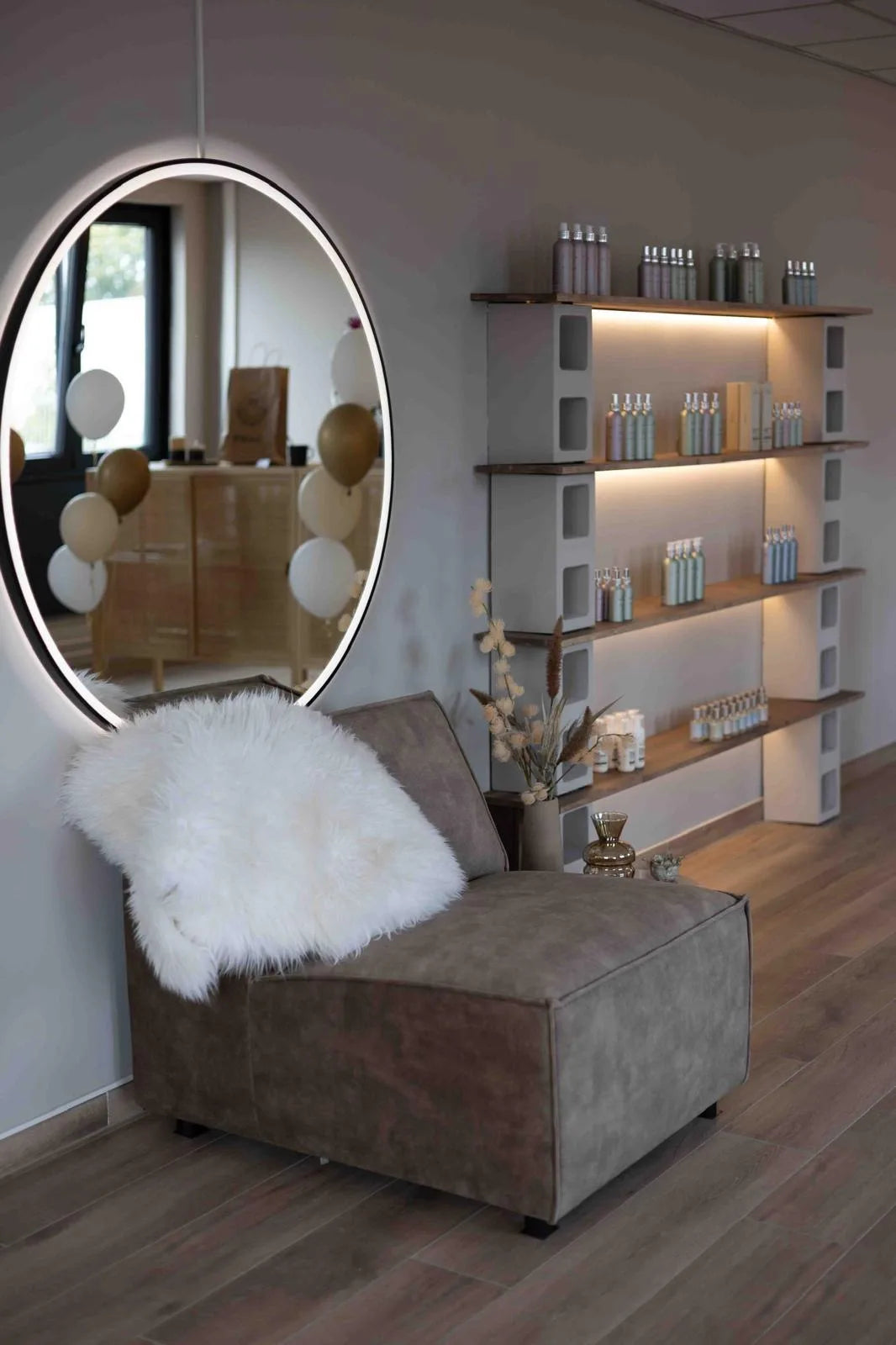 Zithoek met verlichte spiegel en verzorgingsproducten in de salon